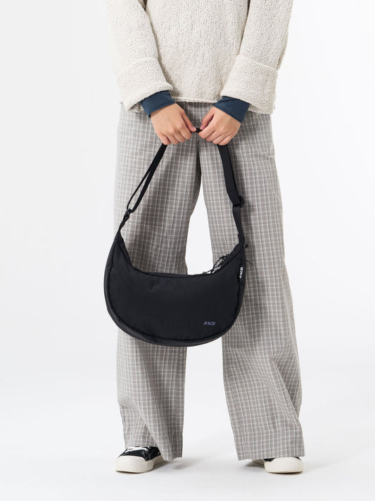 AEVOR-Bike-Sling-Bag-Black-model-front